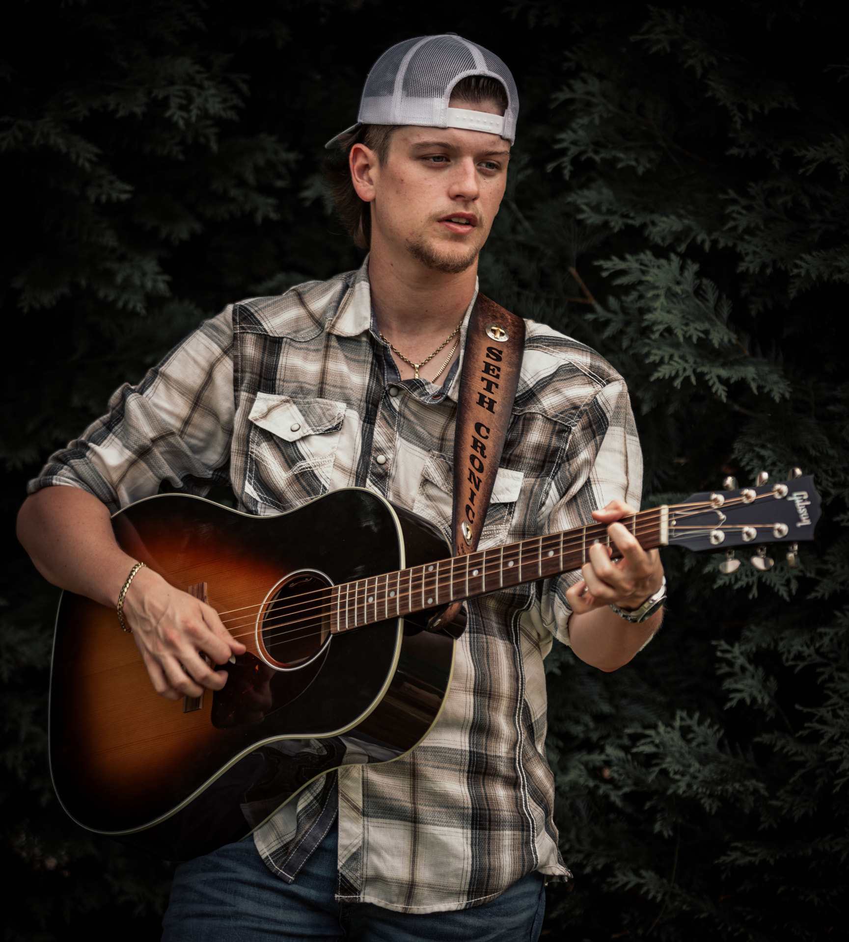 Seth Cronic playing acoustic guitar outdoors