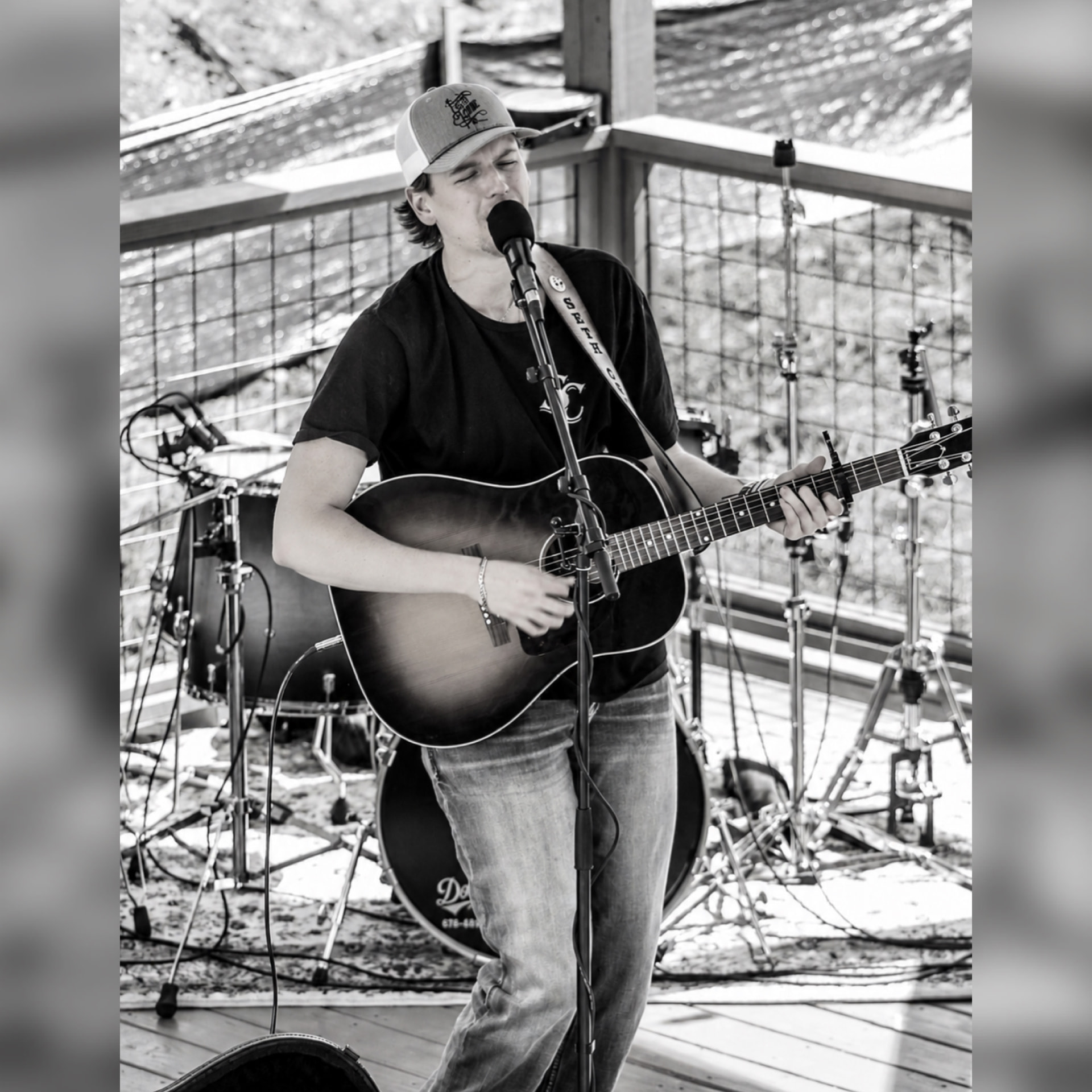Seth Cronic performing with acoustic guitar on an outdoor stage
